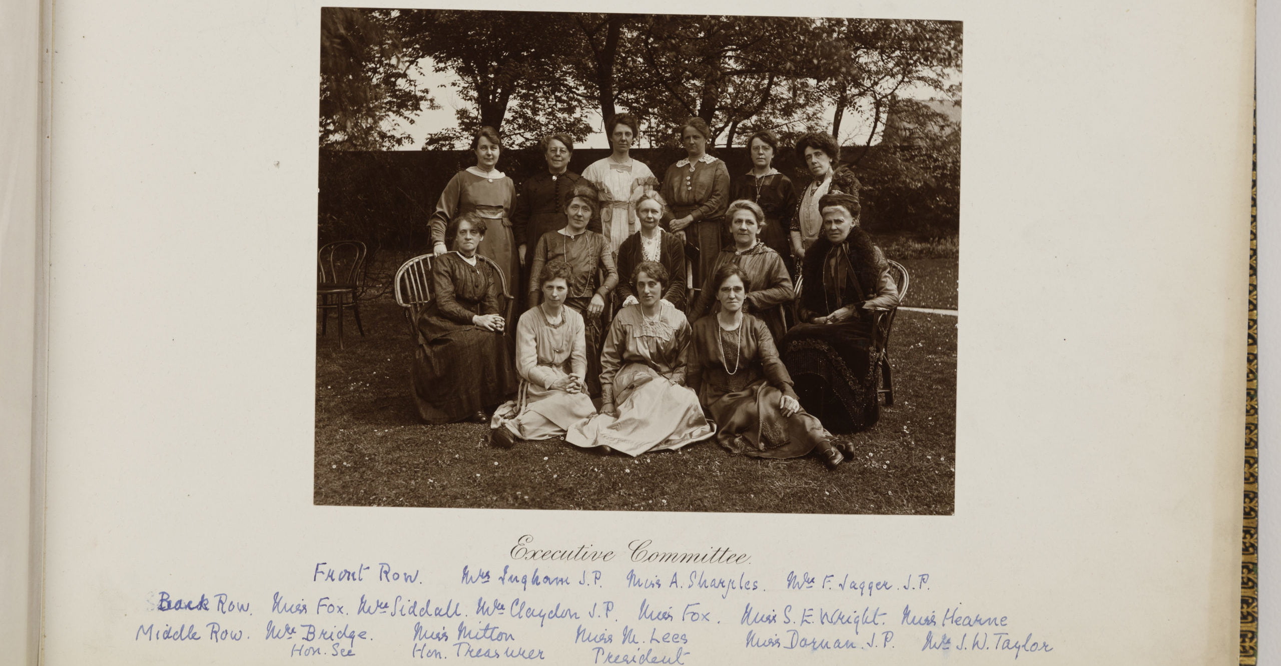 Sepia photograph of women in the Victorian era wearing dresses all posed sat together