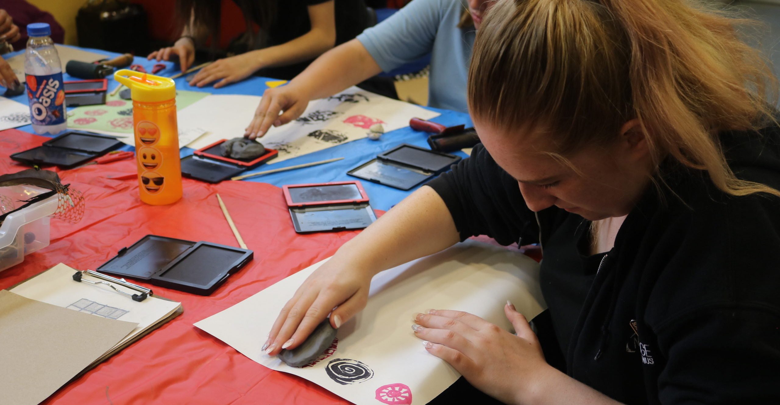 Young person prints shapes on paper with stamps