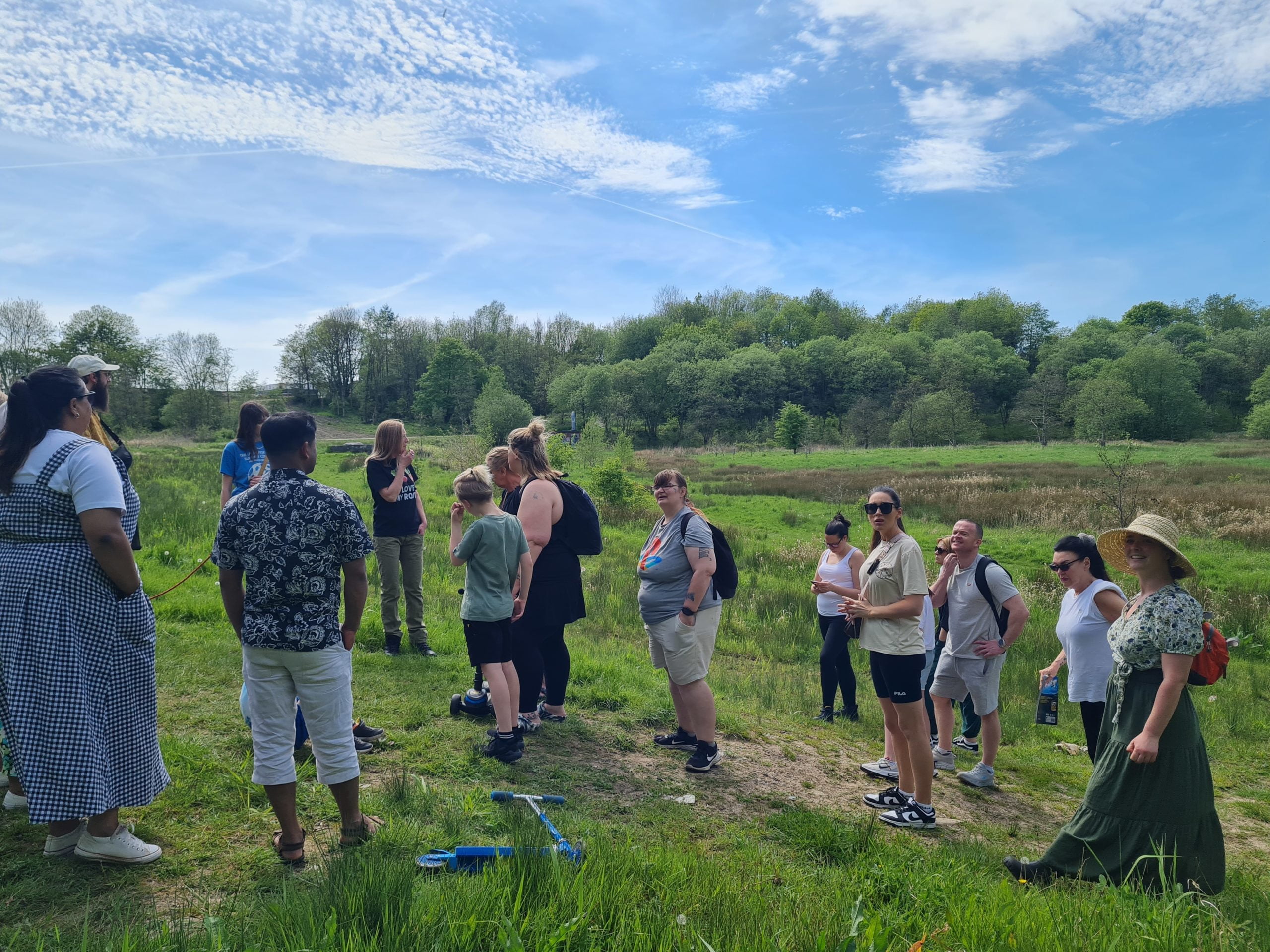 Photograph of a group of people in a field at the Northern Roots site in Oldham.