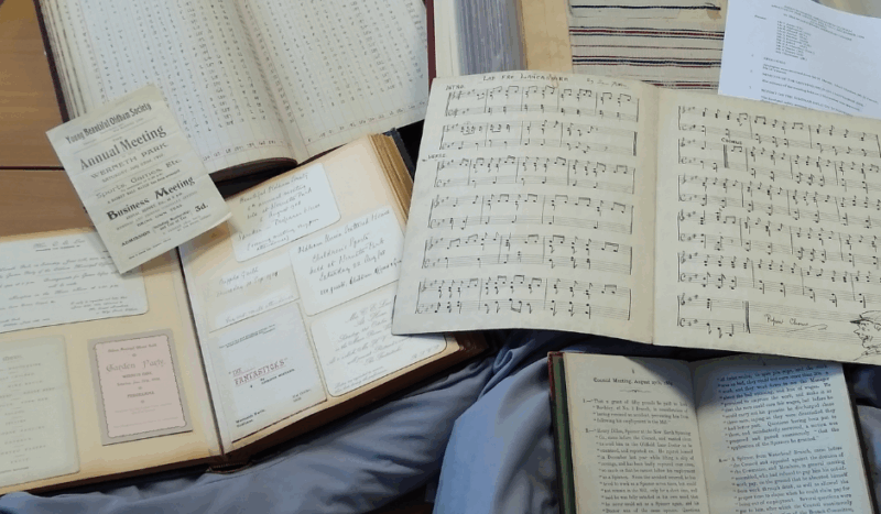 A photograph of different local history books open and resting on supportive pillows on a table.