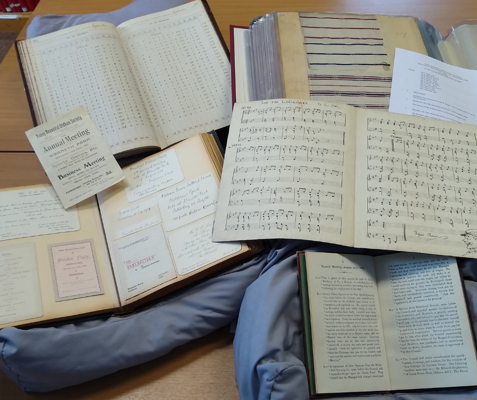 A photograph of different local history books open and resting on supportive pillows on a table.