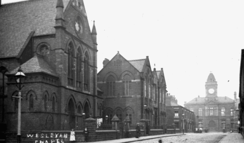 Black and white photograph of the old Wesleyan Chapel in Royton, with the Town Hall in the distance.