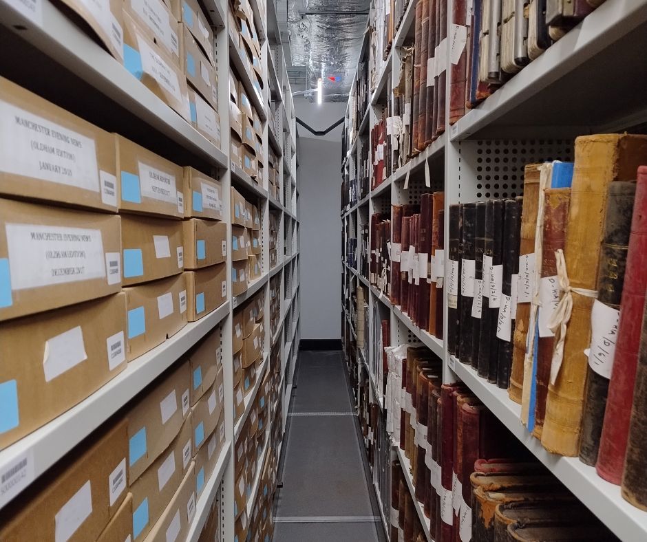 Boxes and books on shelves in the new archives store at Oldham Archives.