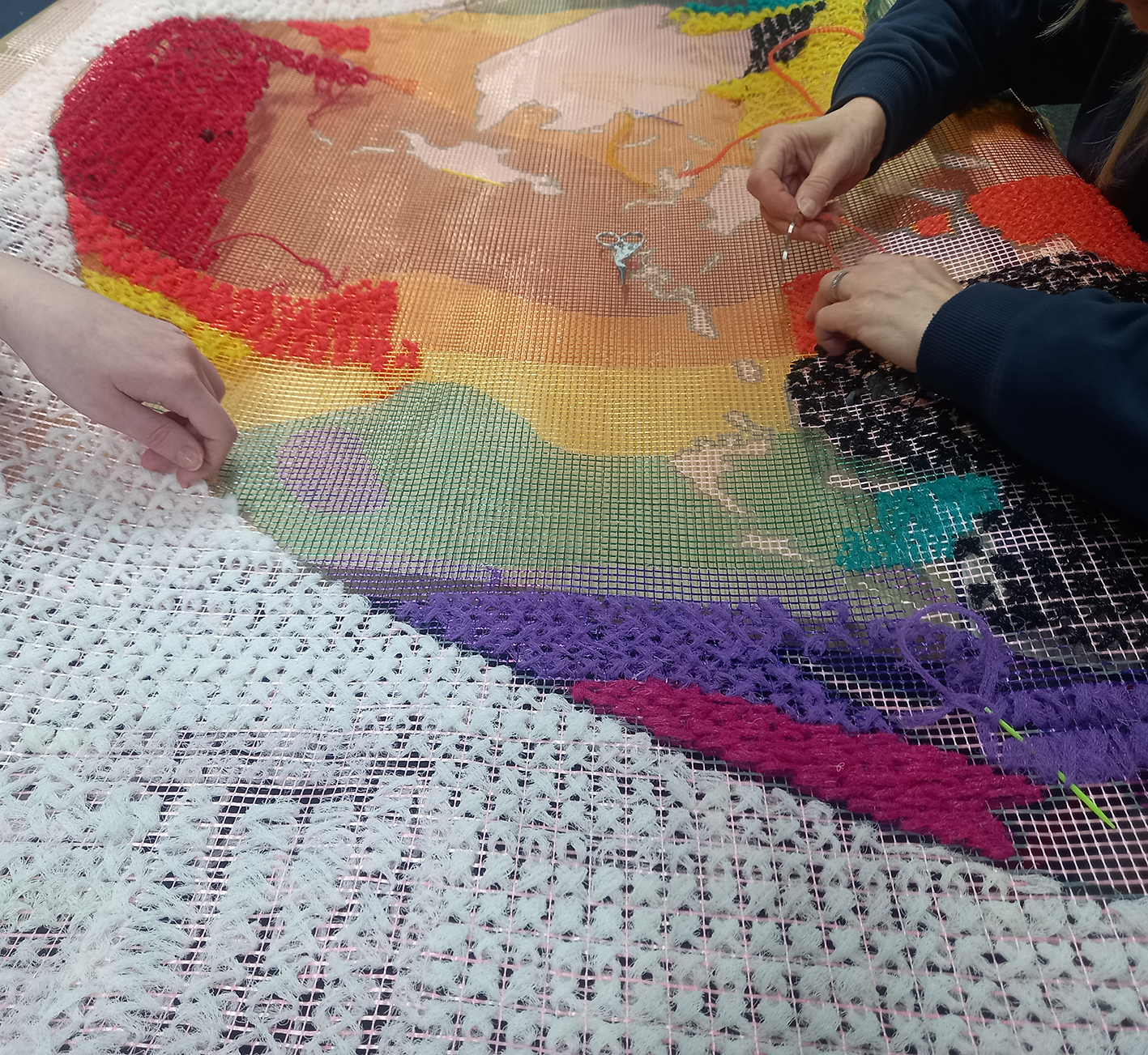 Stitching the World Map showing the map and the hands of someone stitching.