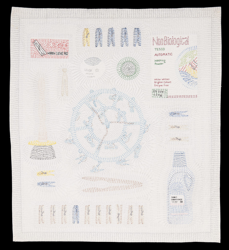 Image of Wash Day Blues showing a textile with laundry items such as pegs, fabric conditioner, washing powder all created with embroidery.