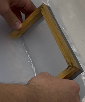 Paper making frame half submerged in water by two hands