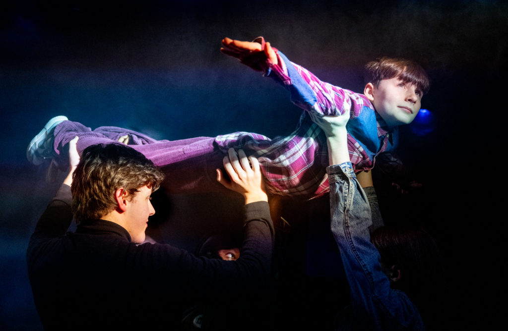 A young boy being lifted into the air so he looks like he is flying